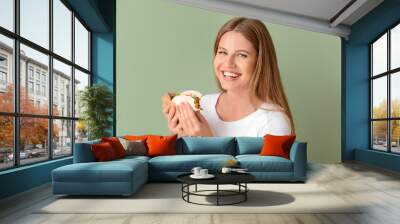 Woman eating tasty taco on color background Wall mural