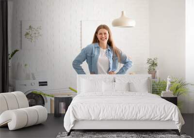 Woman hanging clean clothes on dryer in laundry room Wall mural