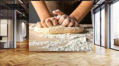 Woman kneading flour in kitchen, closeup Wall mural