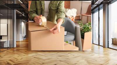 Woman packing moving box at home Wall mural