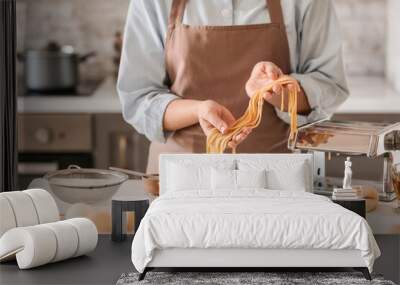 Woman preparing pasta in kitchen, closeup Wall mural