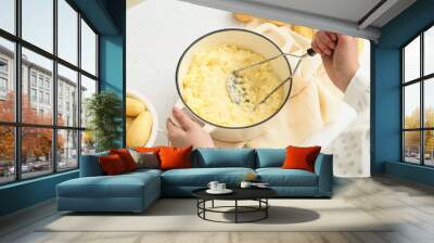 Woman preparing tasty mashed potatoes on light background, closeup Wall mural