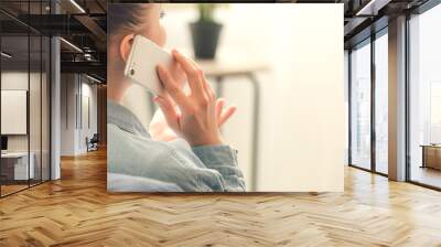 Woman talking by mobile phone at home Wall mural