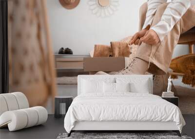 Woman trying on stylish leather boots in boutique, closeup Wall mural