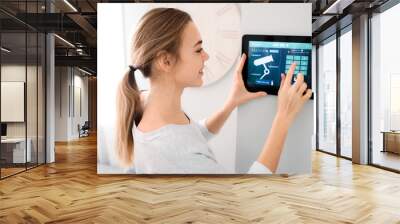 Woman using smart home security system control panel Wall mural