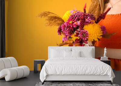 Woman with beautiful autumn bouquet on yellow background, closeup Wall mural