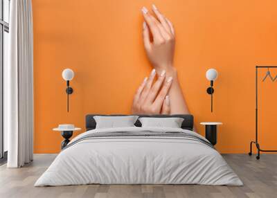 Woman with beautiful manicure on orange background, closeup Wall mural