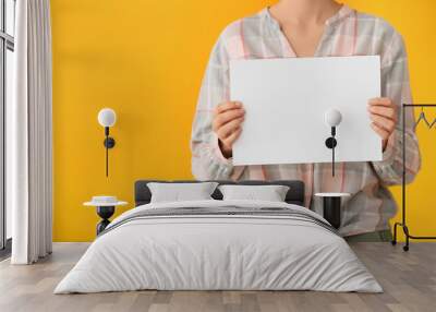 Woman with blank paper sheet on color background Wall mural