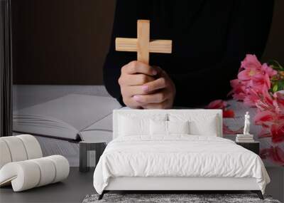 Woman with cross and Holy Bible at white table Wall mural