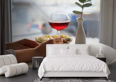 Woman with glass of wine and snacks in cafe Wall mural