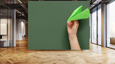 Woman with green paper plane on color background Wall mural