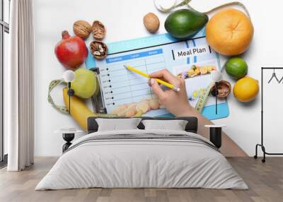 Woman with healthy food filling out meal plan on white background Wall mural