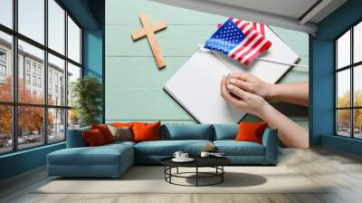 Woman with Holy Bible, USA flag and cross on green wooden background Wall mural