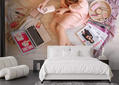 Woman with makeup brushes and laptop shopping online on floor, top view Wall mural