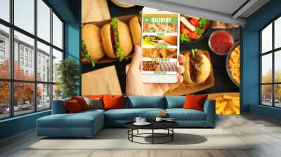 Woman with mobile phone ordering fast food online, closeup Wall mural