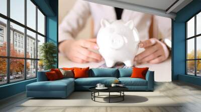 Woman with money and piggy bank at table. Savings concept Wall mural