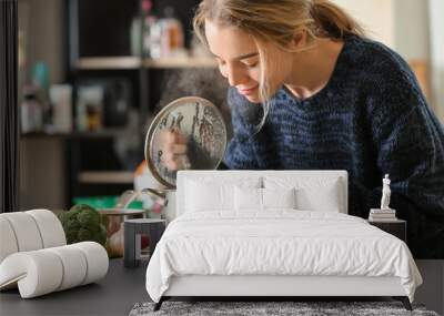 Woman with saucepan of tasty hot soup in kitchen Wall mural