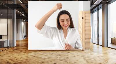 Woman with serum for hair loss treatment at home Wall mural