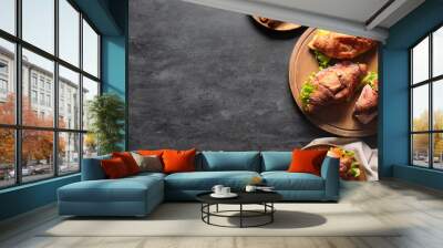 Wooden board and plates with delicious croissant sandwiches on black background Wall mural