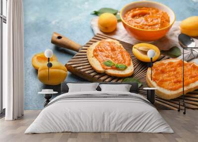 Wooden board of tasty sandwiches with apricot jam on color background, closeup Wall mural