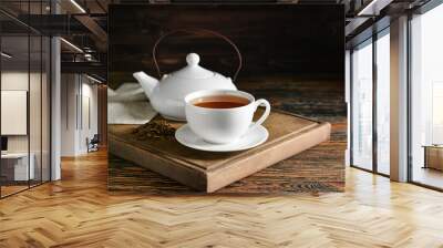 Wooden board with cup of tasty hojicha green tea and pot on table Wall mural