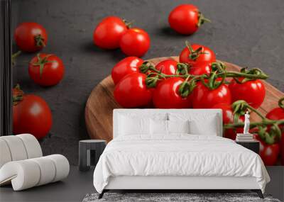 Wooden board with fresh cherry tomatoes on black background Wall mural