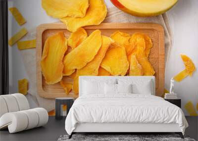 Wooden board with slices of dried mango on white background Wall mural