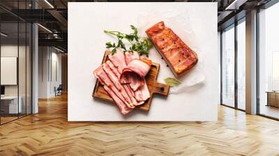 Wooden board with slices of tasty smoked bacon on light background Wall mural