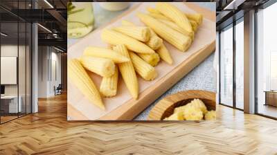 Wooden board with tasty canned corn cobs on light background Wall mural