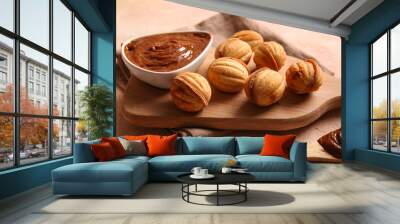 Wooden board with tasty walnut shaped cookies and boiled condensed milk on color table Wall mural