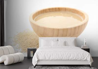 Wooden bowl with tasty tahini and sesame seeds on white background Wall mural