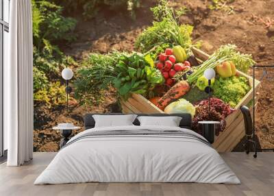 Wooden box with different vegetables in field Wall mural