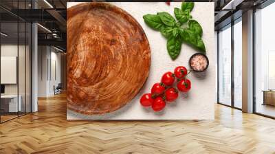 Wooden kitchen board, fresh tomatoes, sea salt and basil on light background Wall mural