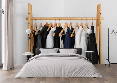 Wooden rack with female clothes near light wall Wall mural