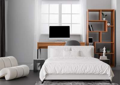 Wooden table with computer and shelving unit near window in office Wall mural