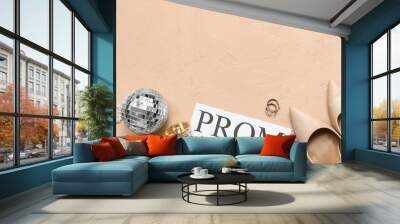 Word PROM with female shoes, disco ball and perfume bottle on beige grunge background Wall mural