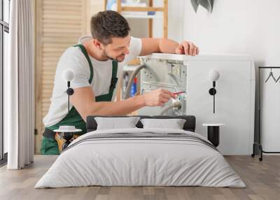 Worker repairing washing machine in laundry room Wall mural