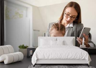 Working mother with her daughter in office Wall mural