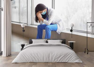 Worried female doctor with medical mask in hall of clinic Wall mural