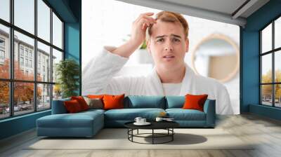 Worried young redhead man with hair loss problem in bathroom, closeup Wall mural