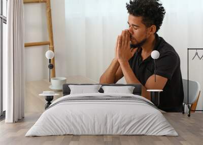 Young African-American man praying at home Wall mural