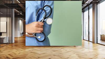 Young African-American nurse with stethoscope on color background, closeup Wall mural