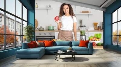 Young African-American woman making healthy smoothie in kitchen Wall mural