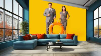 Young business people with lifebuoy on color background Wall mural