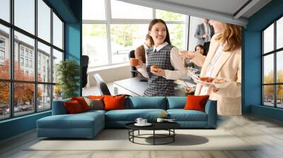 Young business women having lunch in office Wall mural