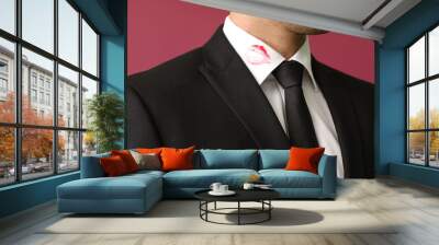 Young businessman with lips print on shirt collar against color background, closeup Wall mural