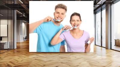 Young couple brushing teeth on white background Wall mural