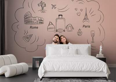 Young couple dreaming about their new journey near color wall in room Wall mural