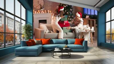 Young couple in love with presents at home on Christmas eve Wall mural