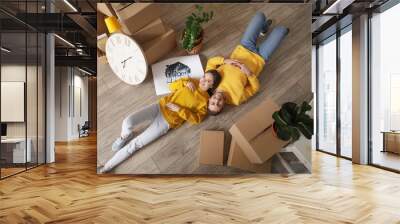 Young couple with belongings in their new house on moving day Wall mural